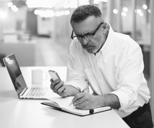 A concerned businessman writing in a notebook