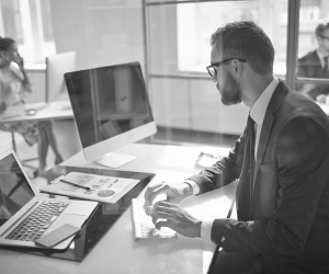 Businessman working at a desk with two computers
