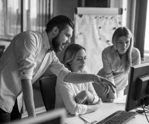 An office team gathered around a monitor