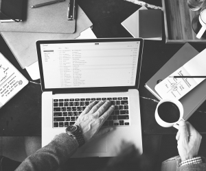 Businessman working at a laptop and holding a cup of coffee