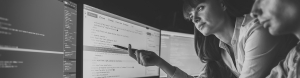 Businesswoman points at lines of code on a screen